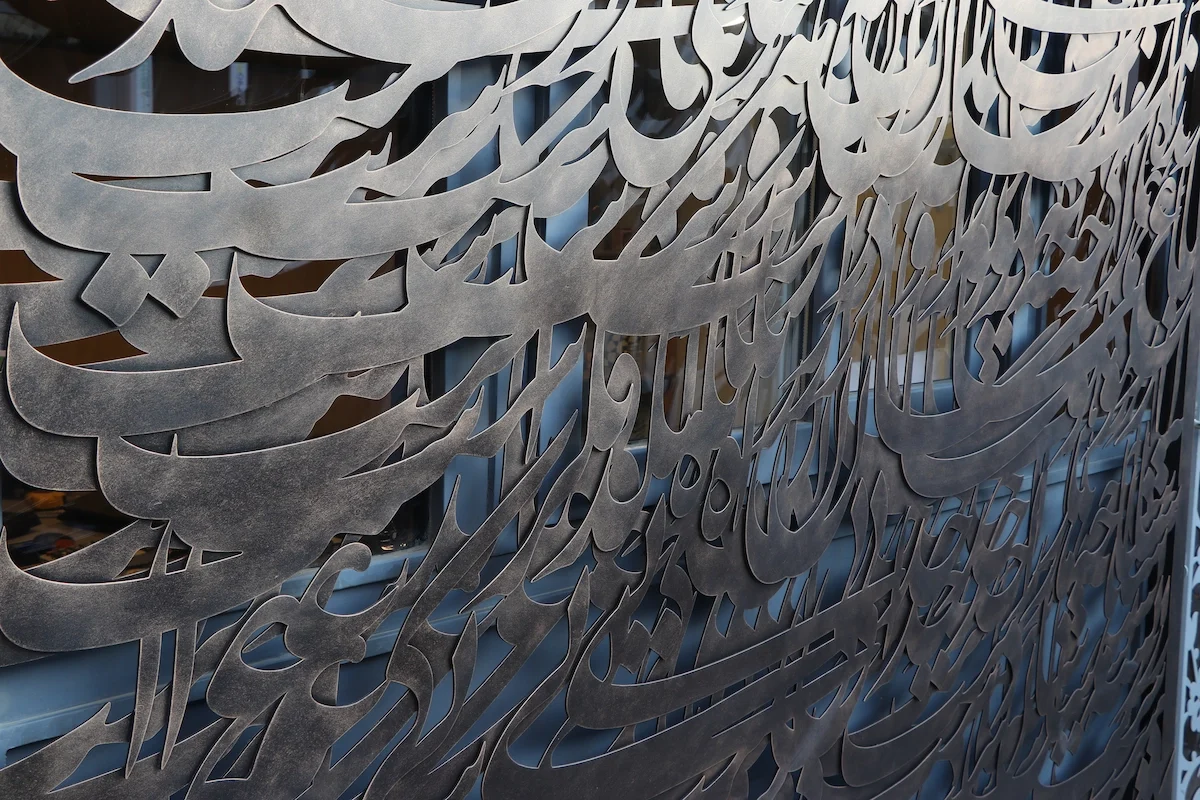 نمای کلی یک حفاظ هنری با نقاشی خط فلزی و روکش پتینه برنز در ابعاد ۳×۴ متر، که با برش لیزری فلز و خوشنویسی با فلز به اثری مدرن و اصیل تبدیل شده است.